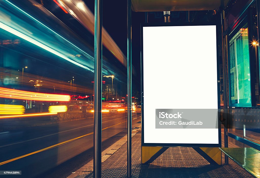 Public information board with blurred vehicles in high speed Illuminated blank billboard with copy space for your text message or content, advertising mock up banner of bus station, Bus Stop Stock Photo