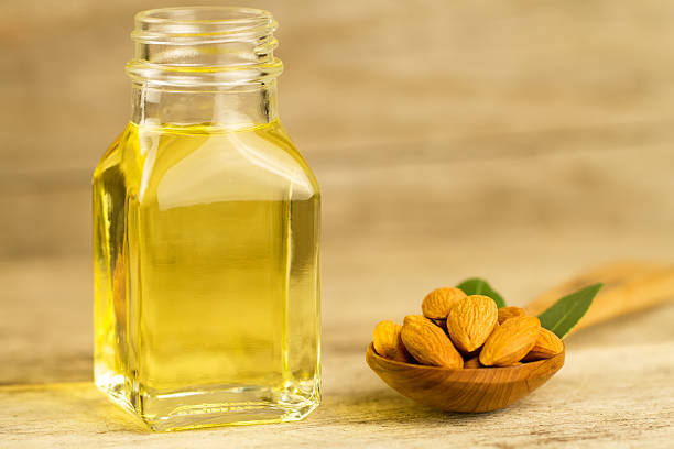 istock peeled almonds in a spoon and oil in a jar 479447292