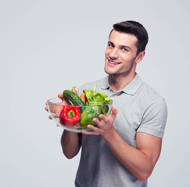 istock Happy young man holding bowl with vegetables 479448156