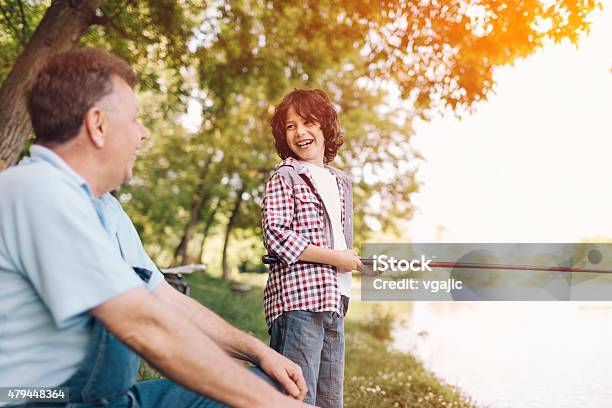 Grandpa And Grandson Fishing Together Stock Photo - Download Image Now - 2015, 60-69 Years, 8-9 Years