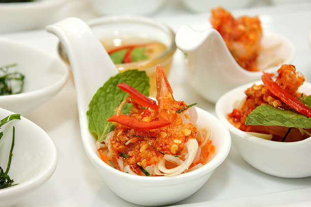 A shrimp with spicy sauce in white spoon