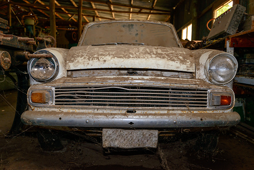 Abandoned vintage car covered with layer of dust in the shed