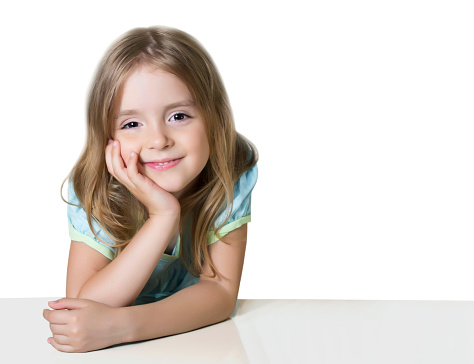 Portrait of a cute smiling girl wearing white dress, close-up. Happy child girl on white background with copy space