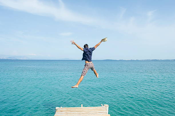 istock Young man jumping from the dock into the sea 479463756