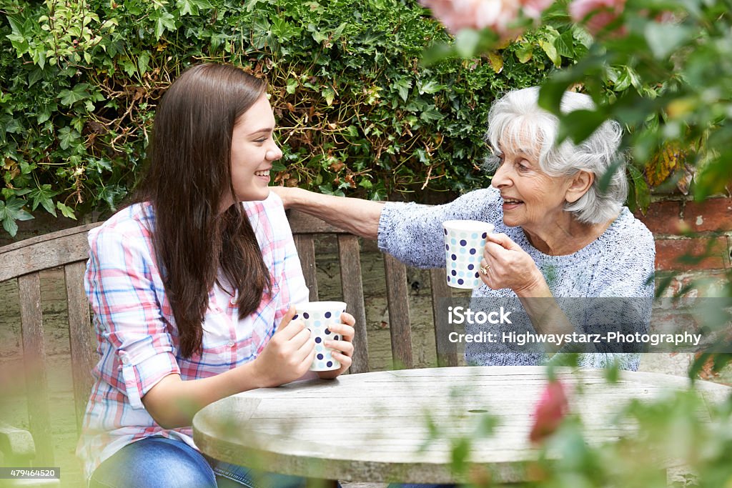 Teenager entspannend mit Großmutter Enkelin im Garten - Lizenzfrei Teenager-Alter Stock-Foto