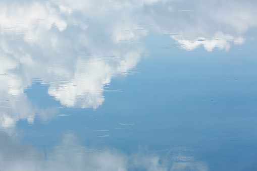 Reflection of blue sky and cloud on sea surface