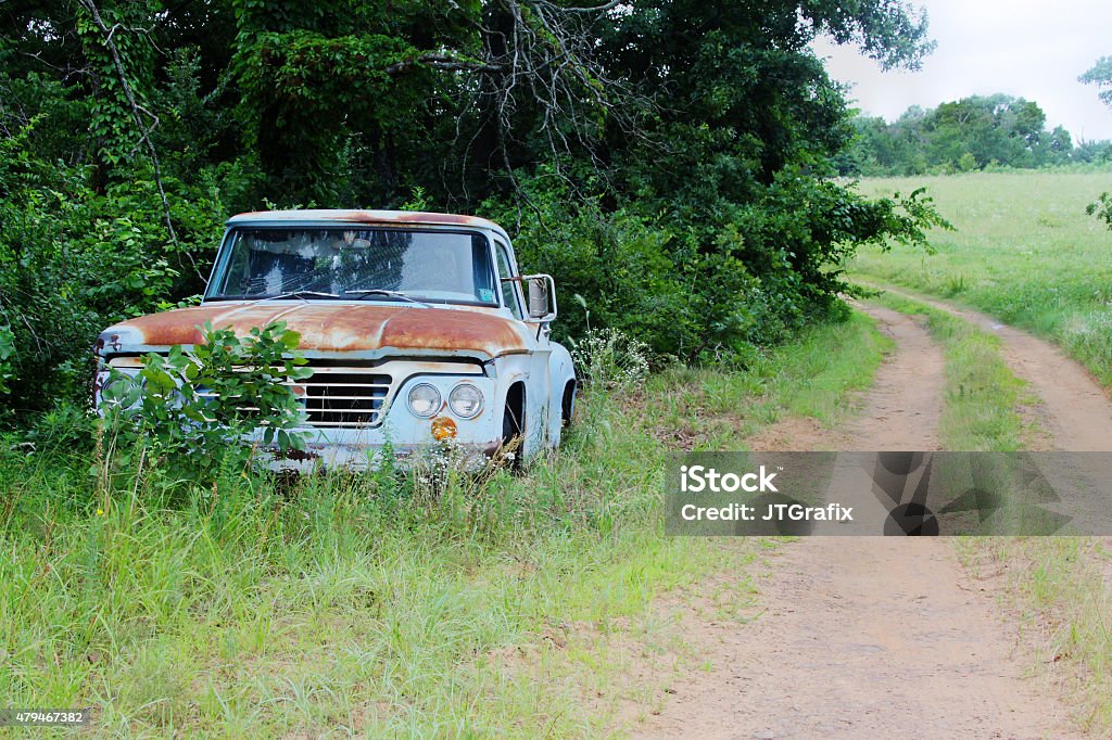 Old Truck in the Country A rusted out old truck is photographed along a country road. Dirt Stock Photo