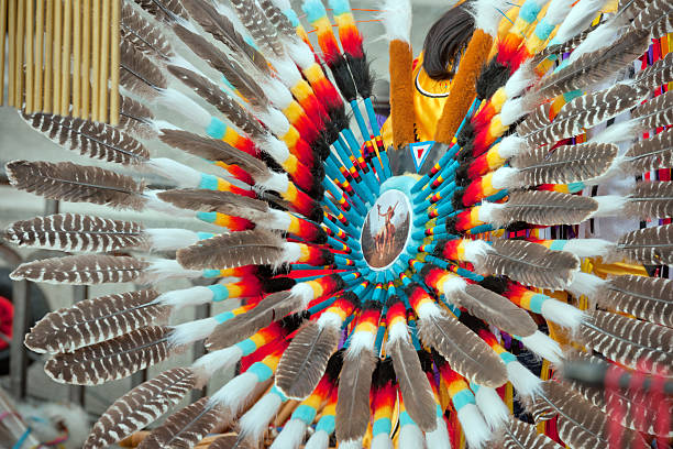 Venice, Italy - March 3rd, 2014: Peruvian musician with his feather hat and pan plute seen from behind at Riva degli Schiavoni near Piazza San Marco at sea side. He is wearing national costume. Venice, Italy.