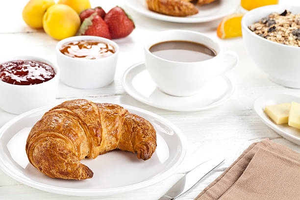 croissant appena sfornato servito su un tavolo da pranzo rustica withe. - non alcoholic beverage comfort food snack dining table foto e immagini stock