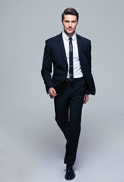 Full length portrait of a fashion male model Full length portrait of a fashion male model over gray background. Looking at camera 2015 stock pictures, royalty-free photos & images