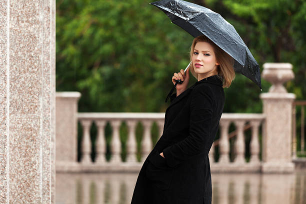 istock Happy woman with umbrella in the rain 479469855