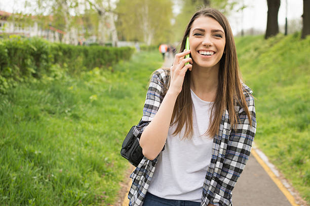 Mujer joven sonriente hablando por teléfono. No retoques - foto de stock