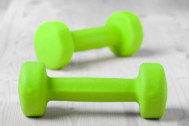 istock small green dumbbells on wooden surface 479470891