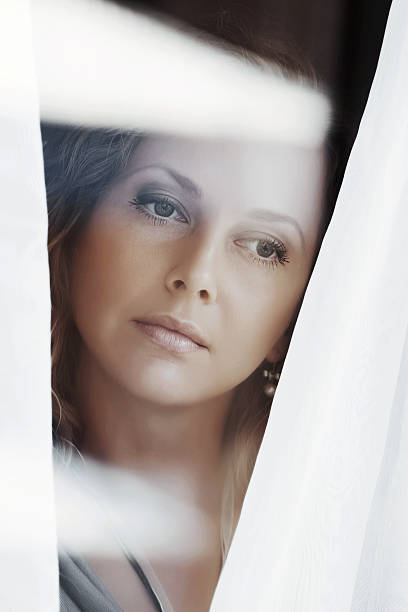 istock Sad beautiful woman looking out the window 479473027