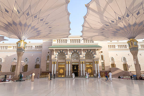 Nabawi mosque Medina, Saudi Arabia - March 6, 2015: Pilgrims walk underneath giant umbrellas at Nabawi Mosque compound. Nabawi mosque is the second holiest mosque in Islam. muhammad prophet photos stock pictures, royalty-free photos & images