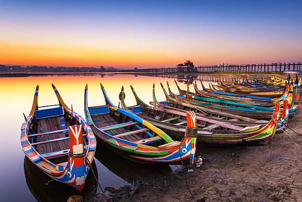 sunrise in the morning at ubein bridge with a boat sunrise in the morning at ubein bridge with a boat mandalay photos stock pictures, royalty-free photos & images