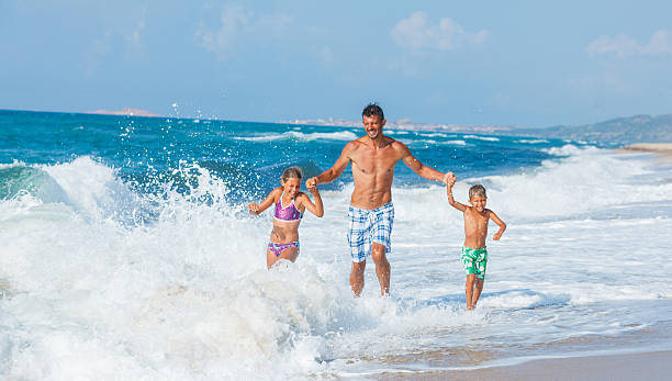 istock Father and children playing on the beach 479480466