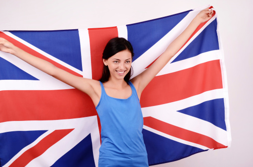 Young woman smiling holding up the UK flag.