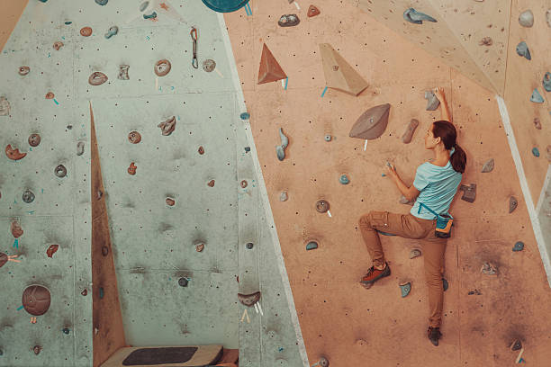 istock Young woman climbing artificial boulder in gym 479484540