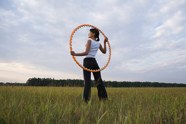 istock Woman Holding Hula Hoop On Field 479484629