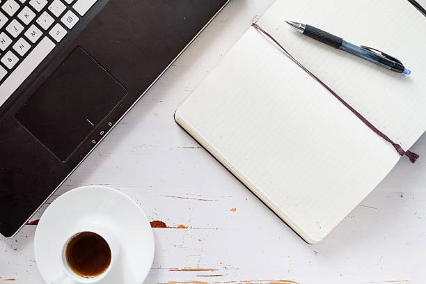 istock Coffee, notebook and laptop, white wood background, top view 479485716