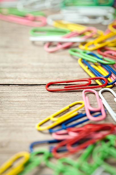 istock Colorful paperclips on old wooden table 479489832