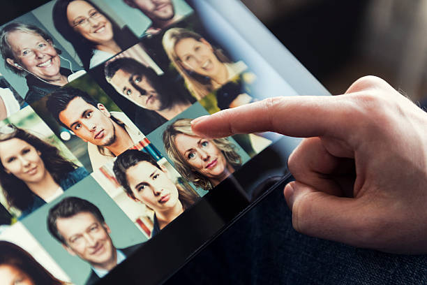 istock Man points at touch screen with image of a woman 479489839