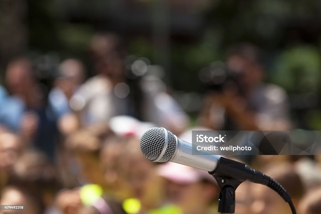 Microphone in focus against blurred audience Microphone in focus against blurred group of people 2015 Stock Photo