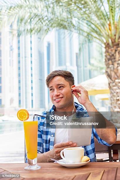Young Man Drink Coffee And Using Tablet In Dubay Stock Photo - Download Image Now - 20-24 Years, 2015, 25-29 Years