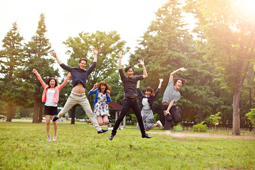 Young asian people having fun in the park, Tokyo. Japanese group young friends jumping in the air together in the park. Concept for urban lifestyle and friendship. Image is taken during Tokyo Istockalypse 2015