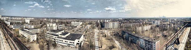 Panorama of abandoned Chernobyl from rooftop on nuclear power pl Panorama of abandoned city Ptyniat in Chernobyl from the rooftop on the nuclear power plant on th right and city center. Bright sunny day in spring. Chernobyl reactor 4. chornobyl photos stock pictures, royalty-free photos & images