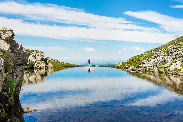 woman hiker explores alpine lake.