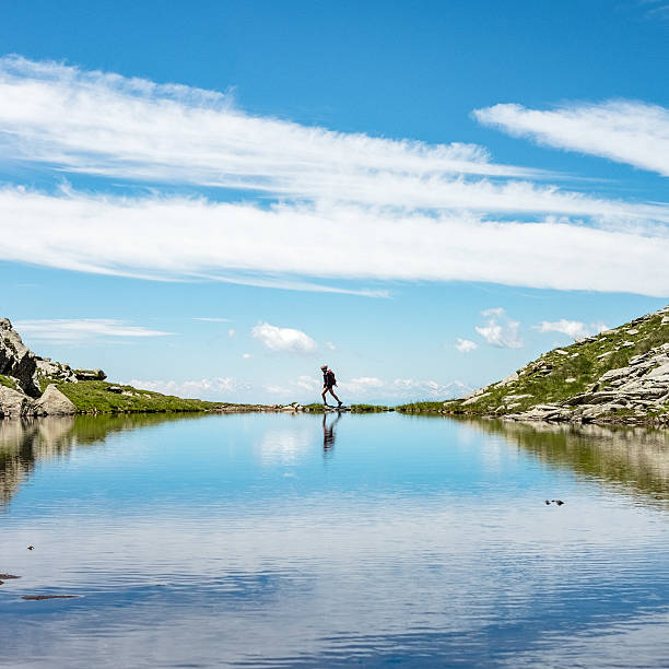 woman hiker explores alpine lake.