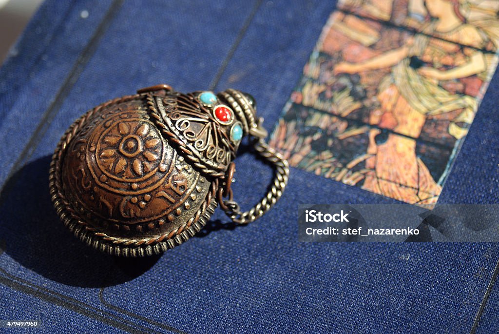 The talisman The vintage talisman with mystical ornament on it and blue and red stones on top. The background is blue. Egypt Stock Photo