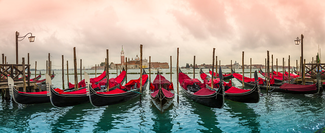 Gondolas moored by Saint Mark square with San Giorgio di Maggiore church in the background - Venice, Venezia, Italy, Europe.