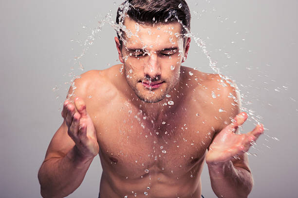 istock Young man spraying water on his face 479498754