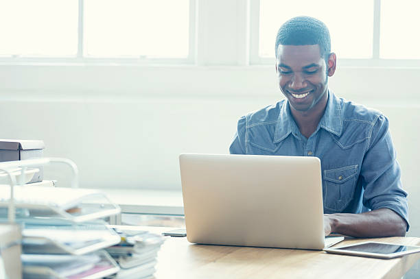 afro americano uomo lavorando su un computer portatile. - young adult business casual computer foto e immagini stock