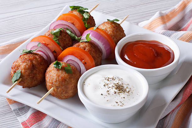 istock Delicious meatballs on skewers with sauce on a plate horizontal 479502012