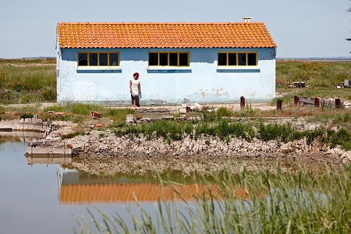 Mature hispanic woman standing outside oyster farmer hut in France