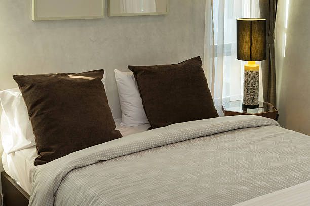 istock brown pillows on bed with lamp 479512272