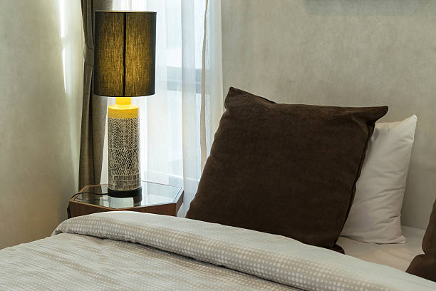 istock brown pillows on bed with lamp 479512282