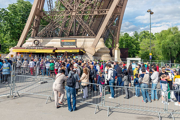 touristes attendent près de billetterie de la tour eiffel, à paris - vacations women men stability photos et images de collection