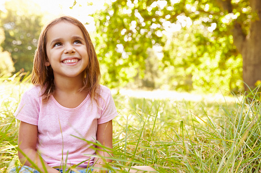 Portrait of a young girl sitting outdoors on a sunny day