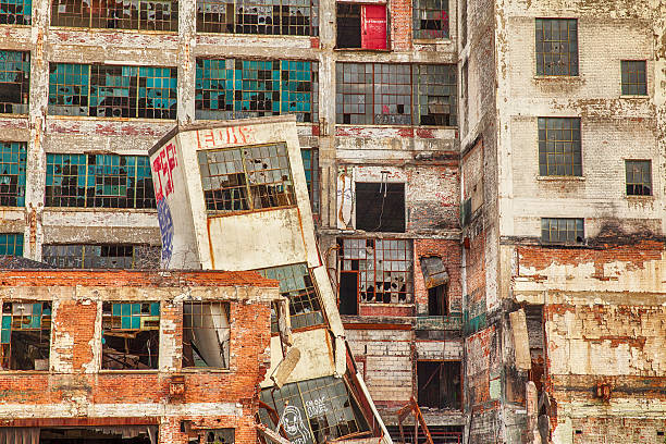 Urban Decay At Detroit Factory Detroit, USA - June 12, 2015: A collapsed tower, broken windows, and graffiti at the old Fisher Body Works factory highlight the post-industrial urban dilemma in Detroit. The factory was opened in 1919 and closed in 1984. detroit ruins stock pictures, royalty-free photos & images