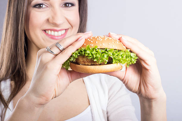 istock woman eating a hamburger 479516275