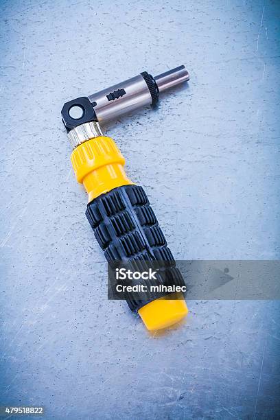 Metal Reversive Screwdriver With Rubber Handle On Metallic Backg Stock Photo - Download Image Now