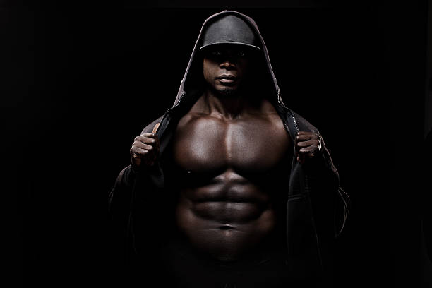 negro muscled hooded hombre usando una tapa - hooded shirt men macho hood fotografías e imágenes de stock