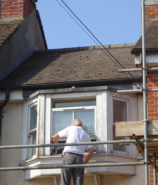 istock Image of builder repairing rotten wooden window frame on house 479519914