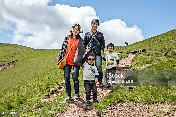 Asian Family Of Four On Hillside Trek In Wales Stock Photo - Download Image Now - Family, Blue, Green Color