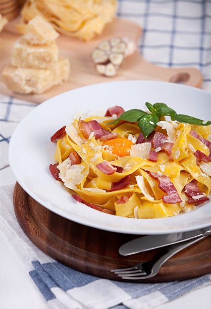 istock Pasta carbonara with tagliatelle spaghetti, egg yolk, bacon and basil. 479524384